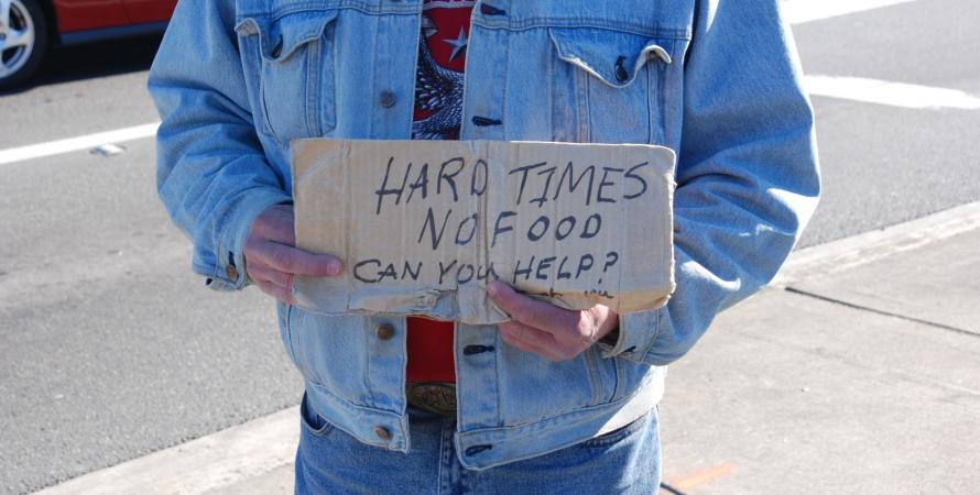 A man in Kirkland, Washington holds handwritten sign asking for help.